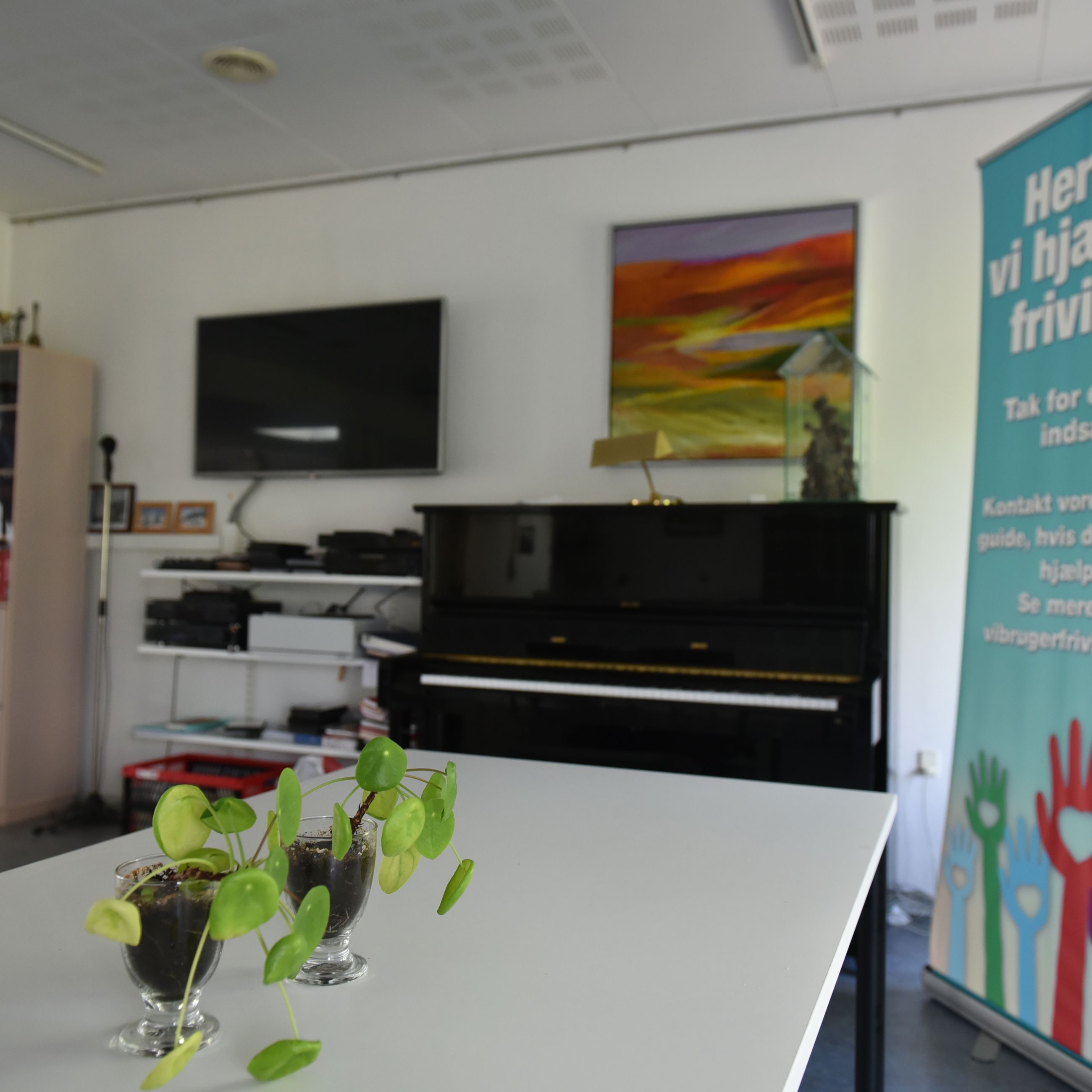 Opholdsrum med spisepladser og klaver hos Spentrup Ældrecenter